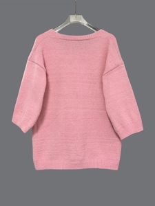 Detail eines rosa Strickpullovers in Oversize-Passform mit überschnittenen Schultern