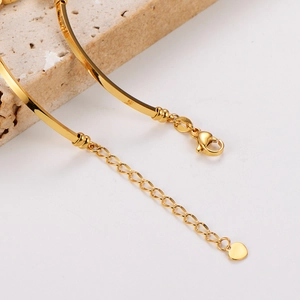 Close-up of golden butterfly bracelet with heart charm, lobster clasp and extender chain