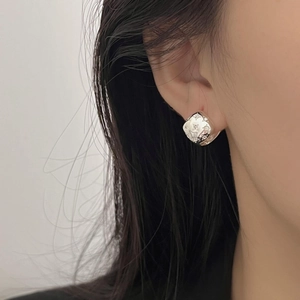 Close-up of S925 silver square stud earring with flower engraving worn on the ear