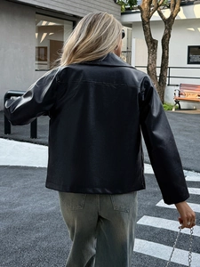 Vista posteriore di una giacca in ecopelle nera minimalista su una modella all'aperto