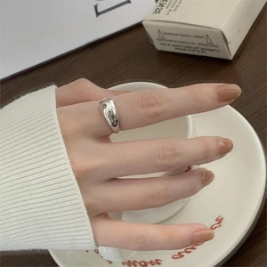 Polished silver teardrop ring shown in a lifestyle setting holding a coffee cup
