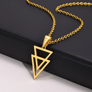 Detail of gold geometric double triangle pendant on O-chain necklace over black box