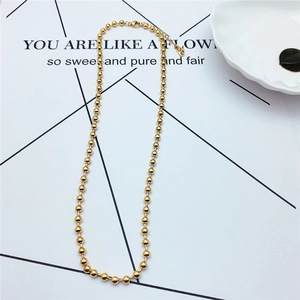 Detailed close-up of golden beaded titanium necklace with adjustable lobster clasp