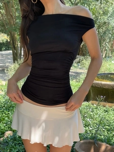 Top nero con spalle scoperte e design a pieghe abbinato a una gonna a pieghe bianca