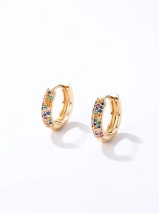 Gros plan de boucles d'oreilles huggie dorées avec des zircons colorés effet arc-en-ciel