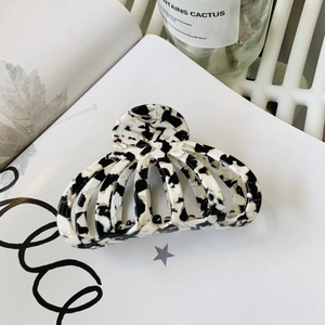 Détail macro d'une grande pince à cheveux en acétate avec motif marbré noir et blanc
