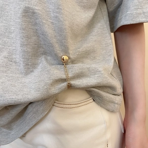 Close-up of gold metal magnetic chain buckle for t-shirt shortening on a grey shirt
