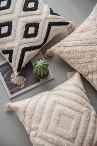 Macro detail of Moroccan style tufted texture and corner tassels on a bohemian cushion cover