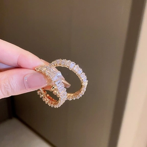 Detailed view of gold hoop earrings set with shimmering baguette-cut cubic zirconia crystals