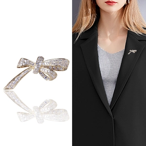 Elegant gold bow brooch with micro-pave cubic zirconia crystals on a black blazer