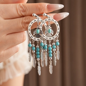 Retro-Ohrringe im Boho-Stil mit Türkisperlen und silbernen Federquasten-Details