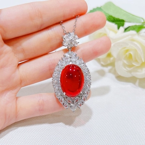Pigeon blood ruby pendant set with oval red gemstone and sparkling zircon halo