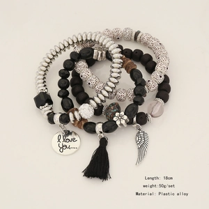 Detail of bohemian layered beaded bracelets with tassels and wing charm, 18cm length