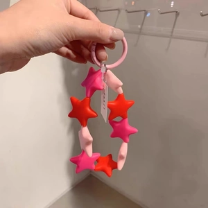 Pink and red silicone star beaded keychain strap with round ring on wrist