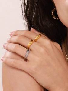 Close-up of elegant polished gold and silver teardrop rings on a female model