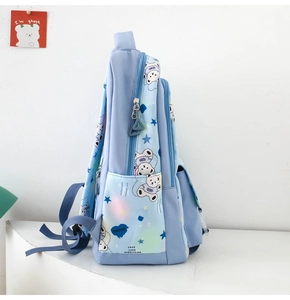 Detail of light blue cartoon backpack showing side pocket and adjustable straps