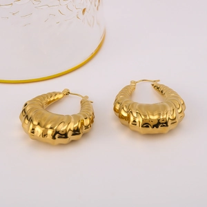 Macro shot of 18k gold plated U-shaped earrings with unique rippled texture surface