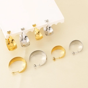 Chic polished gold and silver C-shaped stainless steel earrings on a display stand