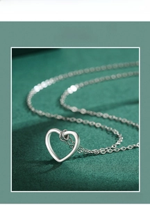 Gros plan détaillé du pendentif coeur évidé en argent S925 sur une chaîne délicate
