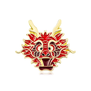 Exquisite red and gold dragon head brooch with enamel detail on a white background