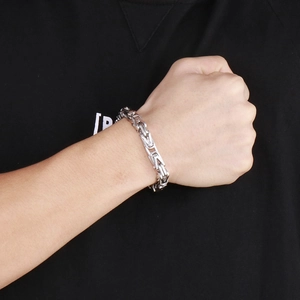 Close-up of a silver Byzantine-style stainless steel chain bracelet on a male wrist