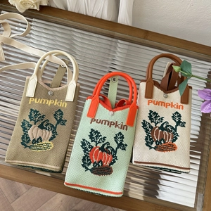 Detailed close-up of three knit mini pumpkin crossbody bags in khaki, beige and green