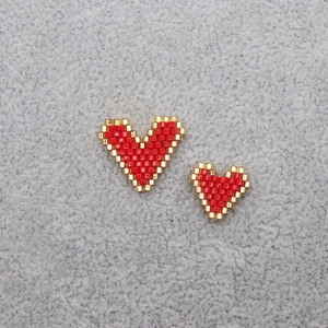 Bohemian Miyuki handmade heart jewelry in red and gold beads on a grey background