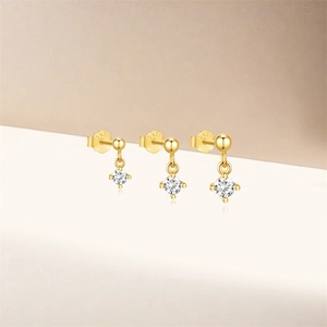 Detailed macro shot of three S925 sterling silver gold-plated stud earrings with cubic zirconia