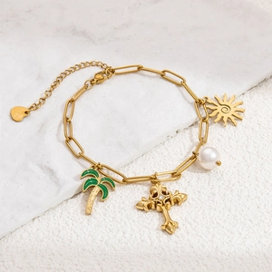 Detail of 18K gold-plated paperclip bracelet with pearl, palm tree, and sun charms