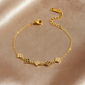 Gold stainless steel bracelet with black and white clover charms and crystal inlays