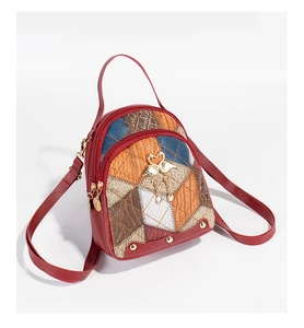 Détails du liseré en cuir rouge et du patchwork multi-texturé du mini sac à dos