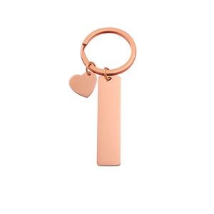 Detail of rose gold rectangular and heart pendants on a stainless steel keychain