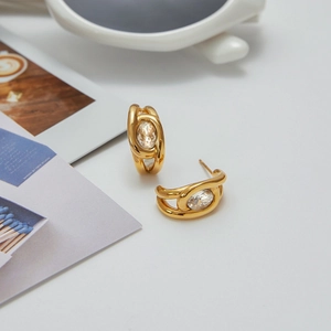 Detail of gold-plated C-shaped stainless steel earrings with sparkling zircon inlay
