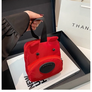 Detail of red bear-shaped mini handbag with cute 3D ears and black handle straps