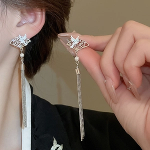 Detail of Chinese style earrings featuring crane fan motif with pearl tassels on a model