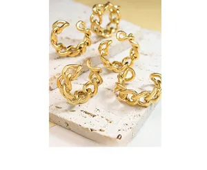 Detailed view of polished gold chain rings displayed on white natural textured stones