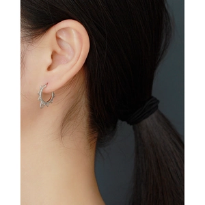 Close-up of vintage hollow sunflower earrings in silver on female model's ear