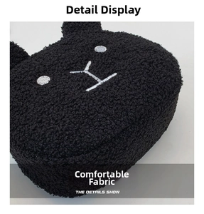 Detail shot of black faux shearling fabric with cute white embroidered animal face