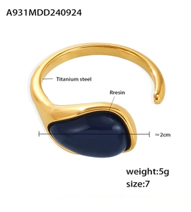 Detail showing an oval blue resin inlay on a 2cm wide titanium steel open ring band