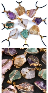 Macro detail of natural amethyst and quartz pendants with gold-plated edges and textures