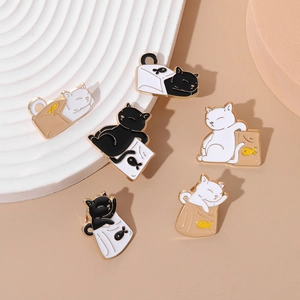 Detail view of cartoon enamel cat pins in paper bags with polished gold metal finish