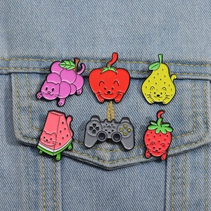 Close-up of colorful cat fruit enamel pins pinned on blue denim jacket pocket