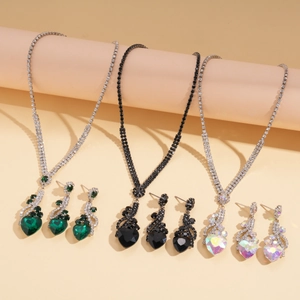 Détail macro de parures vintage avec pendentifs cœur et boucles d'oreilles en strass colorés