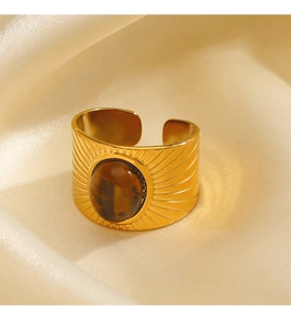Detailed view of a gold geometric wide ring featuring a tiger eye stone on silk fabric