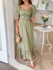 Détail de la robe verte à col carré volanté avec taille froncée et tissu texturé