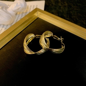 Detailed view of twisted gold hoop earrings with multi-layered spiral texture design