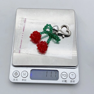 Detailed weight measurement of a handmade crystal beaded cherry keychain with silver heart clasp