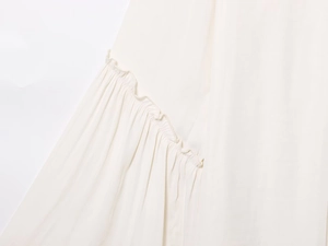 Detailed close-up of cream pleated chiffon fabric with elegant ruffle stitching detail