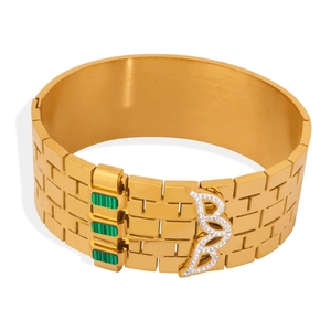 Golden watchband bracelet with brick texture and green stone buckle with pavé crystals