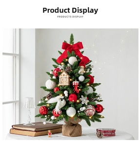 Close-up of mini Christmas tree with red bows, LED lights and rustic burlap base